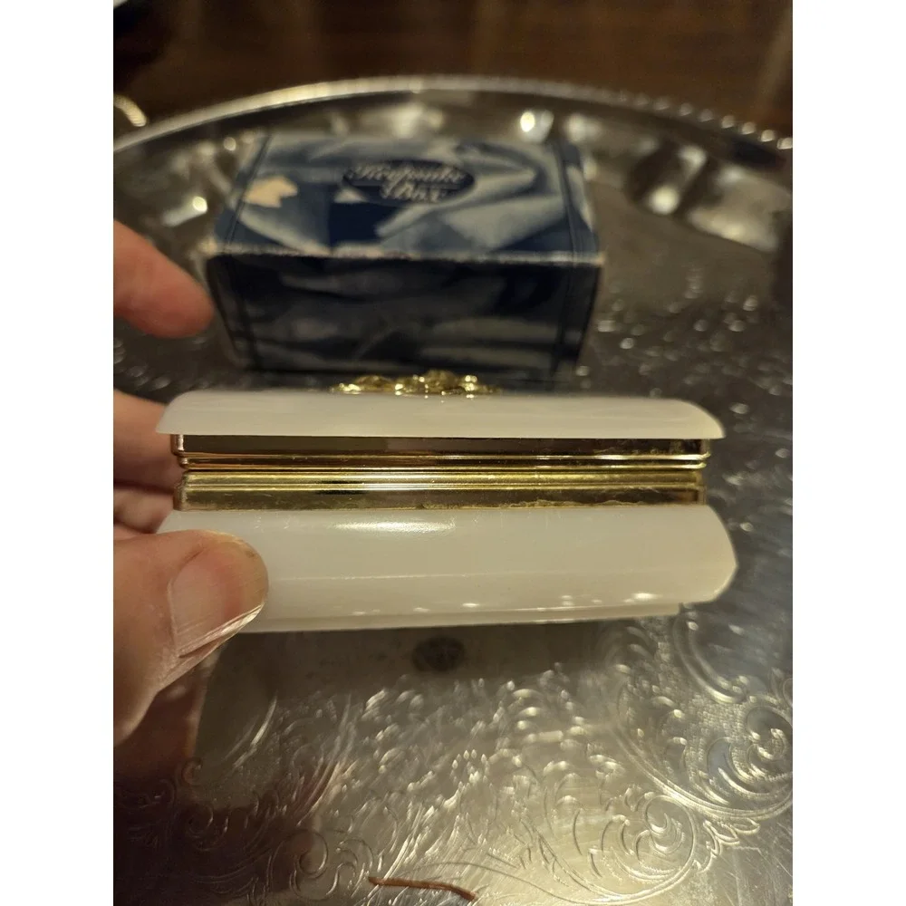 vintage white hinged trinket box features a polished finish with a delicate,...